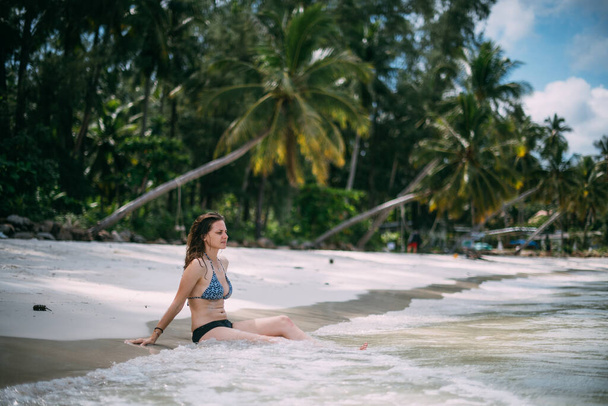 Mayolu güzel bir kadın sahilde sabah egzersizi yapıyor. Bir kadın okyanusta yoga yapıyor. Deniz kenarındaki yogalar. - Fotoğraf, Görsel