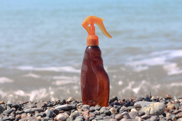 Сонячна пляшка для засмаги на узбережжі моря
 - Фото, зображення