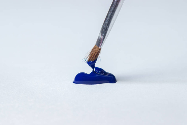 Brosse pour peindre avec de la peinture bleue sur fond blanc. Peinture aquarelle - Photo, image
