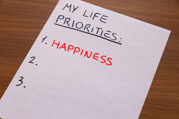 Página de diario blanco, con texto "Mis prioridades" en negro, y "felicidad" en rojo. Prioridad y felicidad, emociones y bienes inmateriales.  - Foto, Imagen