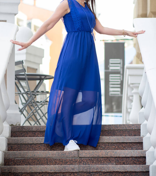 Дівчина в синьому платті ходить по домах на вулицях Києва. - Фото, зображення