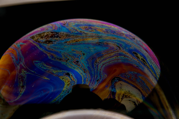 közelkép színes fényvisszaverődésről a szappanbuborék felületén - Fotó, kép