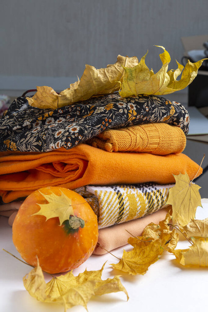 A pile of fall seasonal cloth decorated with autumn leaves and pumpkin - Photo, Image