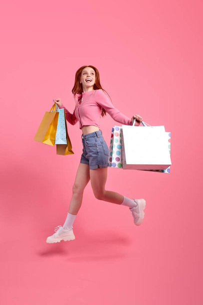 Young redhead young lovely funny funky lady enjoy rejoice shopping, holding packages - Valokuva, kuva