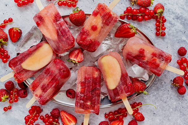 Domowej roboty malina, truskawki, jabłka i porzeczki na metalowej płytce z lodem różne jagody - Zdjęcie, obraz
