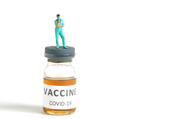 Minyatür insanlar oyuncak fotoğrafçılık. Aşı alternatif seçim konsepti. Ampul şişesinin üstünde duran bir hemşire. Resim fotoğrafı. - Fotoğraf, Görsel