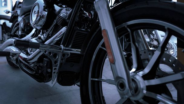 Selective focus on motorcycle frame. Closeup motorcycle exhaust pipe, engine guard, and foot rest. Motorcycle industry. Shiny chrome motorbike engine. Vintage motorbike. Blur aluminum alloy wheel. - Foto, immagini