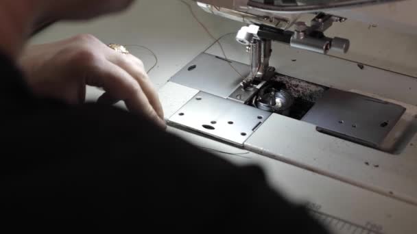 άνθρωπος ράβει μια δερμάτινη ζώνη σε μια ραπτομηχανή - Πλάνα, βίντεο
