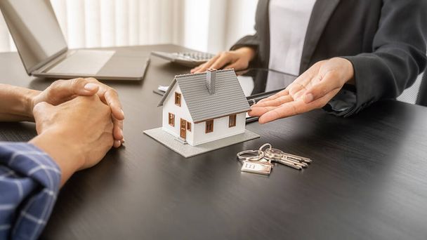 Modèle de maison avec agent et client discutant pour contrat pour acheter, obtenir une assurance ou un prêt immobilier ou immobilier. - Photo, image