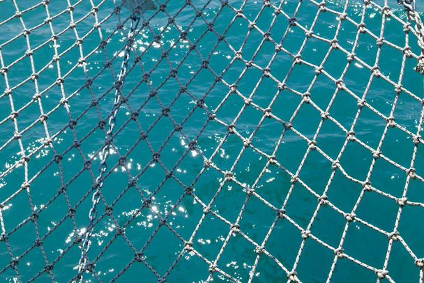 Fényes kék háttér tengeri halászhálóval és homályos tengeri hullámokkal - Fotó, kép