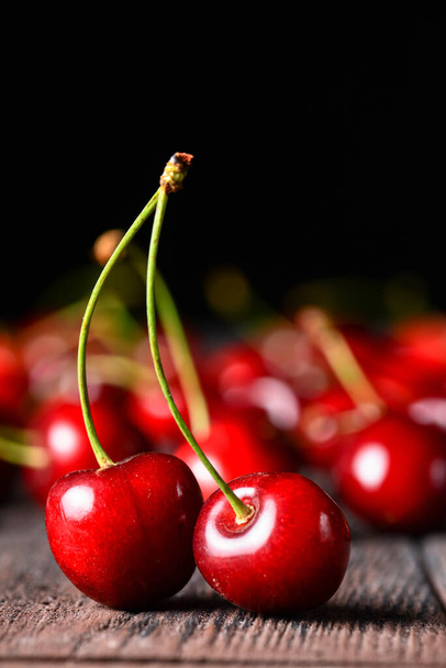 Seasonal fresh cherry fruit over rustic wooden background. Cherry texture, banner. Summer concept, fresh red cherry in rustic style. Close up, selective focus. - Фото, изображение