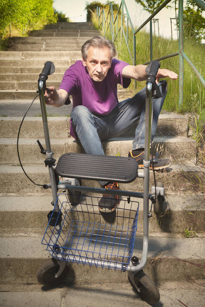 Older man overcoming obstacles with his four wheel rollator walker - Foto, Imagen