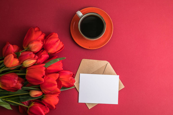 Bouquet of red  tulips and coffee cup arrangement with a lot of copy space for text. Spring mood concept. Greeting card for Birthday, Woman, Mother's Day, Wedding, Valentines day. - Fotografie, Obrázek