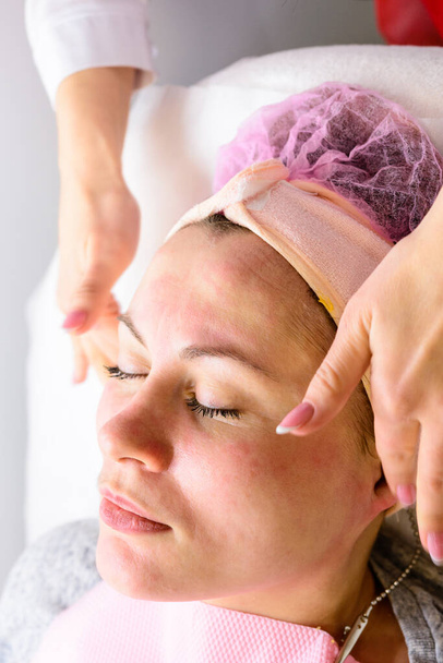 Donna felice e rilassata su procedure cosmetologiche, massaggio e applicazione di crema per il viso. nuovo - Foto, immagini