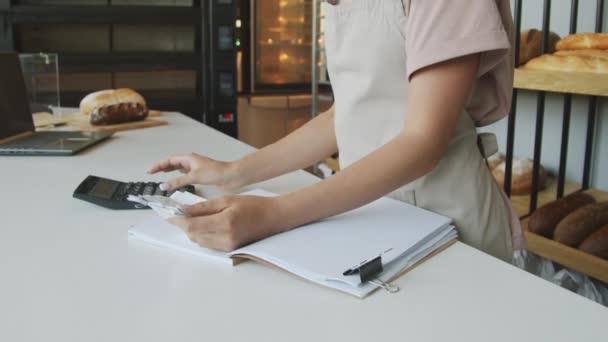 Нахилити повільність веселих молодих жінок-контрабандисток за допомогою калькулятора та перевірки квитанцій у затишній пекарні
 - Кадри, відео