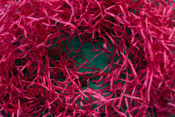 Papel triturado rojo sobre fondo verde - Foto, Imagen