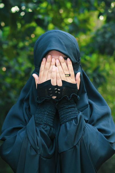 Ασιάτισσα μουσουλμάνα κοπέλα, Πορτρέτο του ευτυχισμένη όμορφη νεαρή γυναίκα θρησκευόμενη φορούν πέπλο μαντίλα αυτή λυπημένος κλάμα χρησιμοποιώντας το χέρι σκούπισμα δάκρυα στα μάτια της. - Φωτογραφία, εικόνα