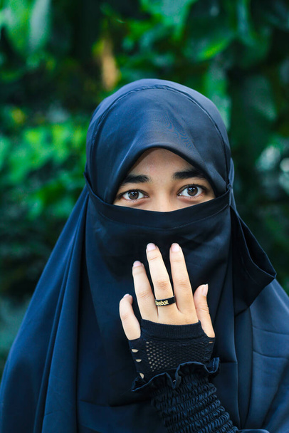 Lähikuva kaunis nainen kasvot peitetty hijabilla. Muslimitytön täydelliset kiiltävät silmät. Nuori niqab tyttö muotokuva taustalla. - Valokuva, kuva