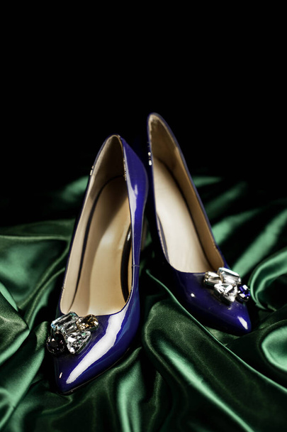 blue womens stiletto heels on a green background - Foto, afbeelding
