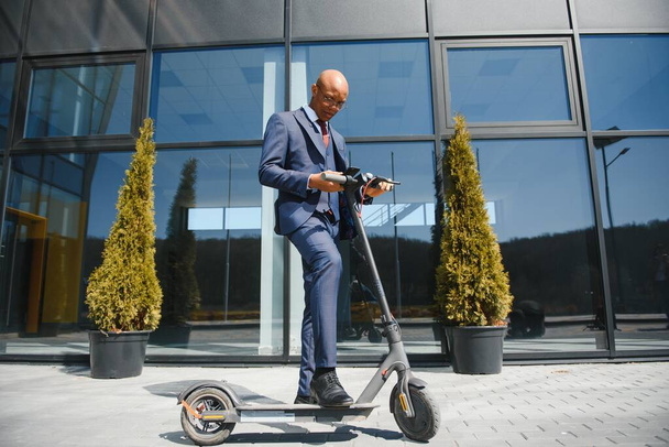 Young African businessman Riding An Electric Scooter - Foto, Bild