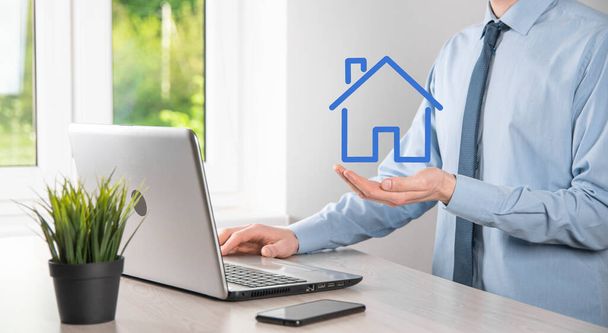 Real estate concept, businessman holding a house icon.House on Hand.Property insurance and security concept. Protecting gesture of man and symbol of house - Photo, Image