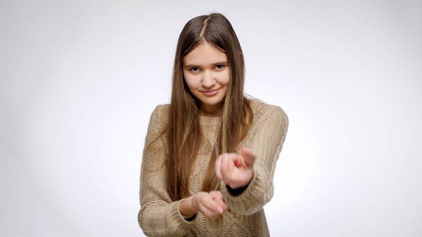Porträt eines flirtenden jungen Mädchens, das unsichtbares Seil zieht und Sie über weißem Studiohintergrund einlädt. - Foto, Bild