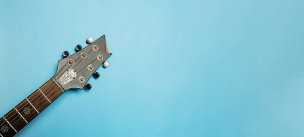 Akusztikus gitár nyak közelkép kék háttérrel - Fotó, kép