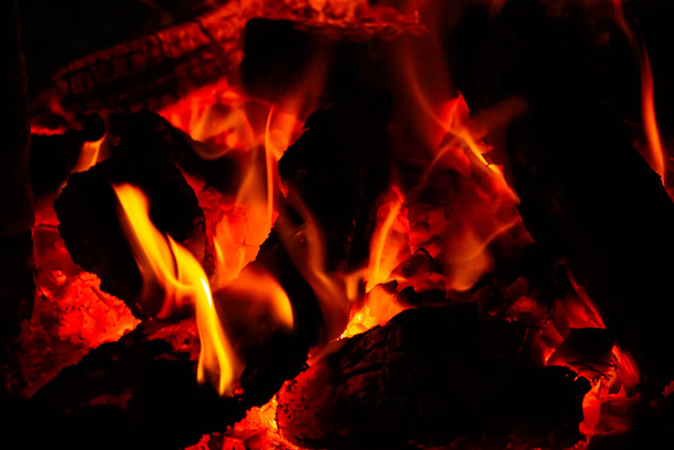 Verwarm de energie van dichtbij, rood en geel, thermische energie op het brandstofpunt tijdens de nacht. Vuur met een zwarte achtergrond voor het behang. - Foto, afbeelding