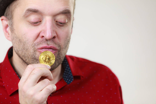 Man holding golden bitcoin coin sign, digital symbol of new virtual currency - Fotó, kép