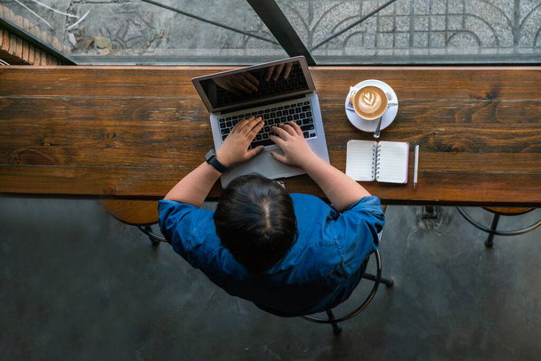 Top view of young freelancer working online on laptop - Φωτογραφία, εικόνα