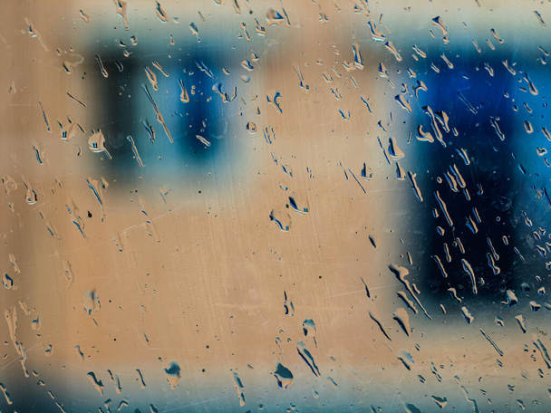 Краплі дощу на синьому скляному фоні. краплі на склі після дощу для шпалер. Краплі на склі, конденсація вікна і тло для тексту
. - Фото, зображення