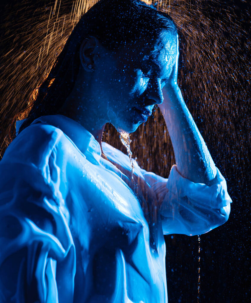 Woman in wet shirt having shower in the dark - Foto, imagen
