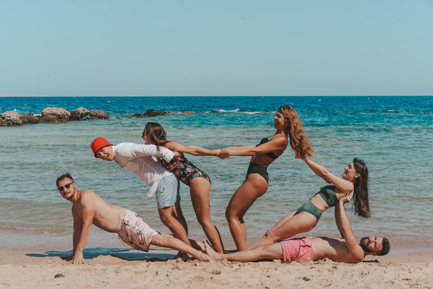 Щаслива група друзів розважається на пляжі
. - Фото, зображення