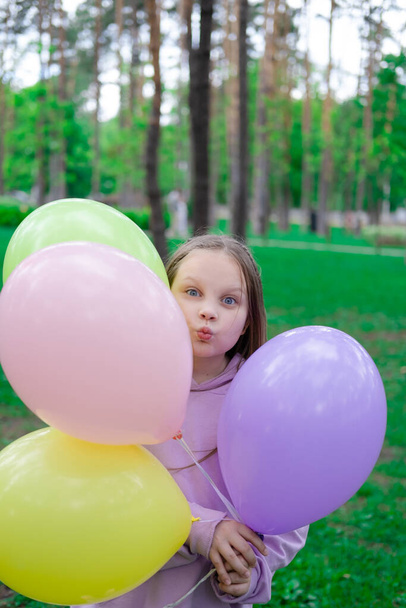 pretty teenage girl with colorful balloons in purple costume in park. happy kids. summer days. vacation, holidays. - Foto, immagini