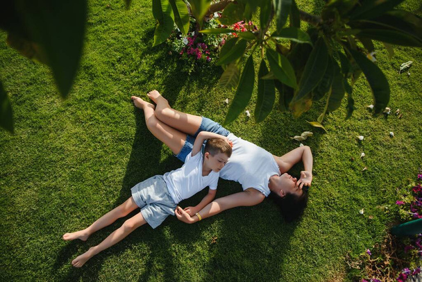 happy young mother with son lying on grass - Foto, immagini
