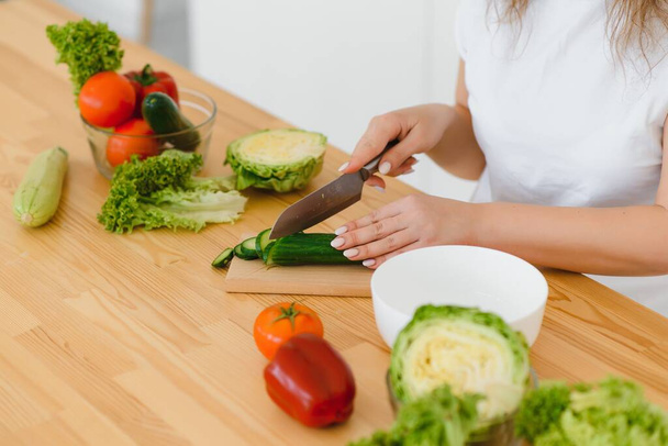 Happy young housewife mixing vegetable salad - Photo, Image