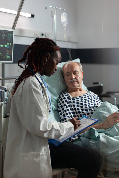 Αφροαμερικανός γιατρός στο δωμάτιο νοσοκομείου συζητώντας τη διάγνωση - Φωτογραφία, εικόνα