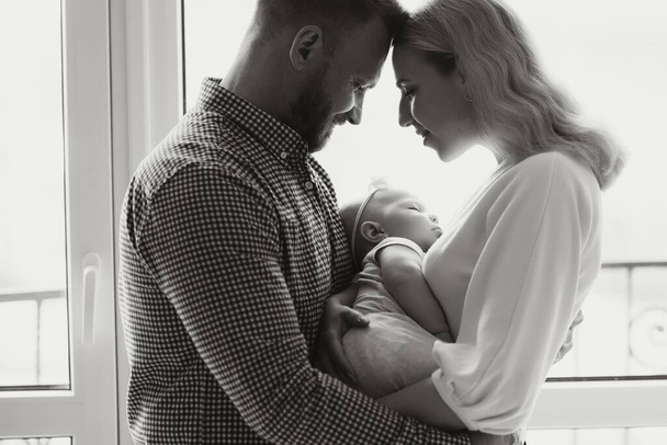 View at Happy family with newborn baby by the window - Foto, Bild