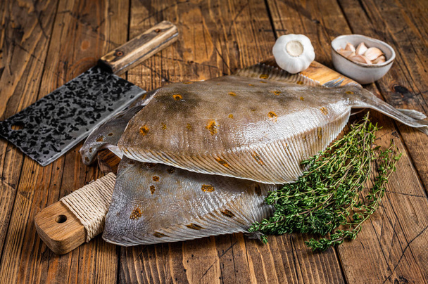 Raw flounder flatfish on butcher board with cleaver. wooden background. Top view - Photo, Image