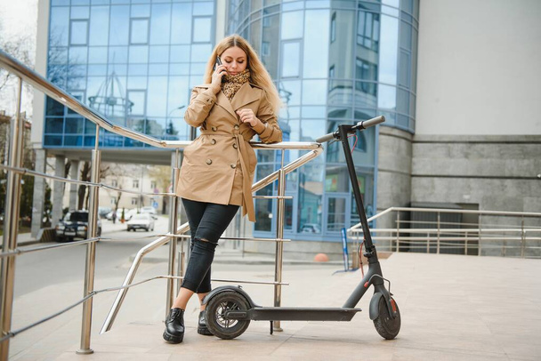 Portrait of a young woman with electro scooter - Valokuva, kuva