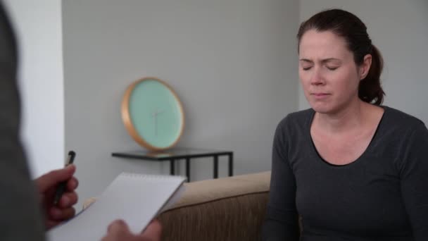Overstuur volwassen vrouw (vrouwelijke leeftijd 30-40) in gesprek met een mannelijke therapeut in psycholoog kliniek. - Video