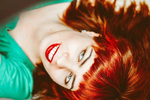 foto de una chica con el pelo rojo, foto de arriba de una chica con lápiz labial rojo - Foto, Imagen