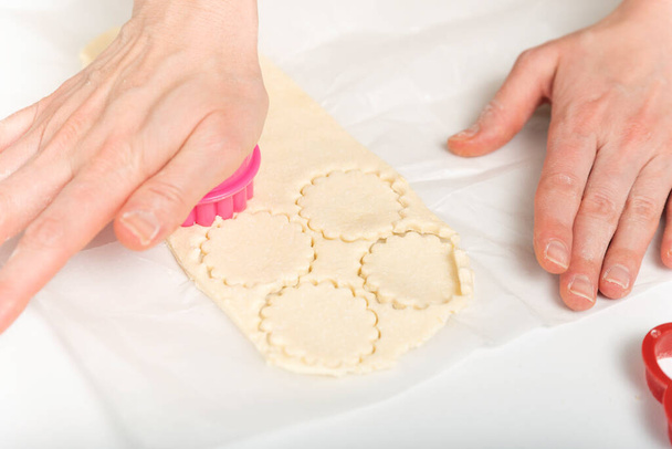 Vrouwelijke handen, koekjessnijders en deeg. Chef bereidt koekjes. Proces van het maken van zelfgemaakte cookies - Foto, afbeelding