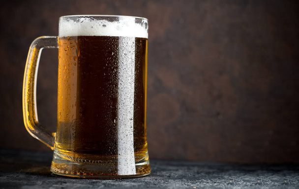 Mug of beer on a dark background with space for inscriptions - Photo, Image