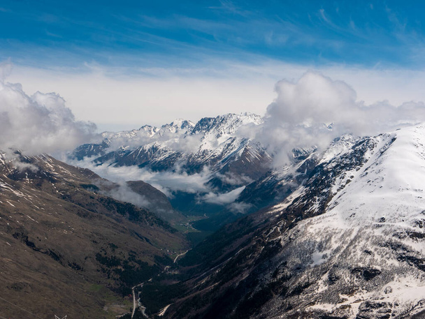 Vista de las montañas del Cáucaso desde Cheget, altura 3050 metros, Kabardino-Balkaria, Rusia. Aquí se puede ver un hermoso desfiladero en el fondo de cielos azules y picos nevados. - Foto, Imagen