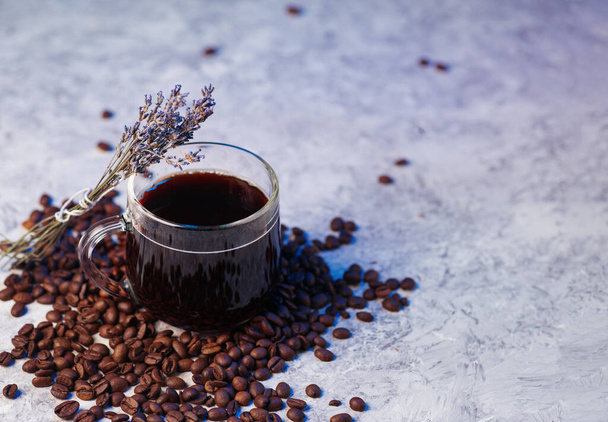 tasse à café expresso en verre, fleurs de lavande, grains de café torréfiés, violet clair coloré - Photo, image