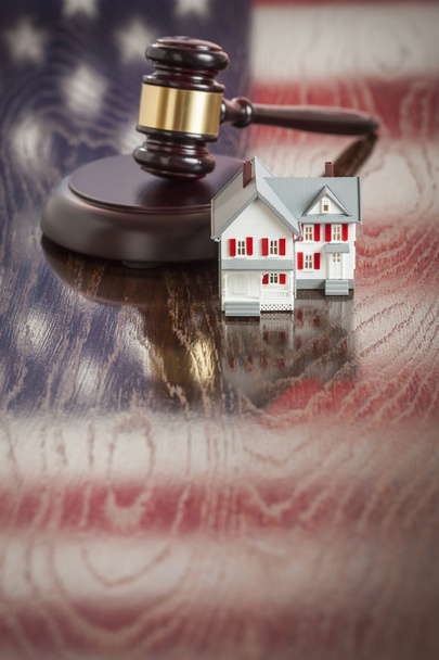klein huis en hamer op tafel met Amerikaanse vlag reflectie - Foto, afbeelding