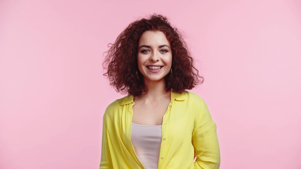 positive and curly young woman isolated on pink - Фото, изображение