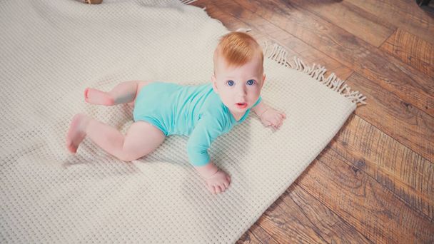 magas szög kilátás csecsemő fiú mászik a takaró és a kamerába - Fotó, kép