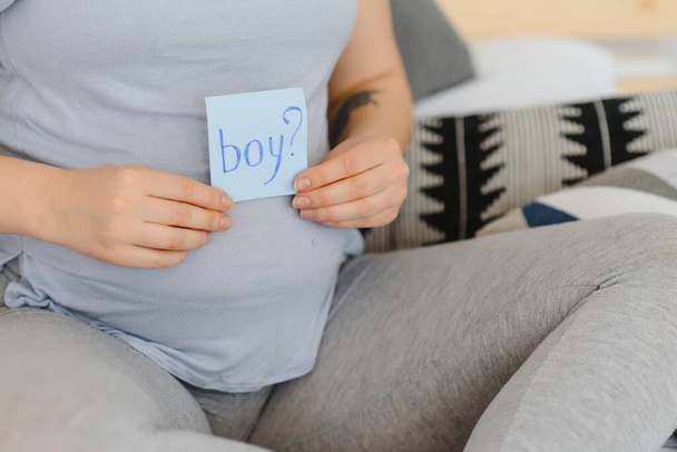 Pregnant woman with a sticky note and writing love boy or girl on sticky note and add on her belly,Pregnant Concept,Selective Focus - Fotoğraf, Görsel